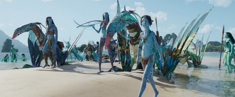 Picture shows a scene from "Avatar: The Way of Water" with Na'vi people and creatures on a beach