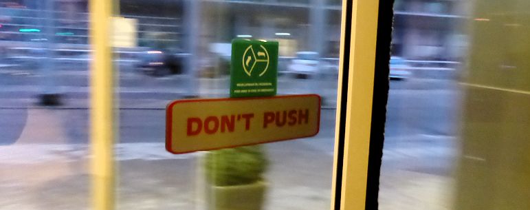 A don't push sign on a revolving door
